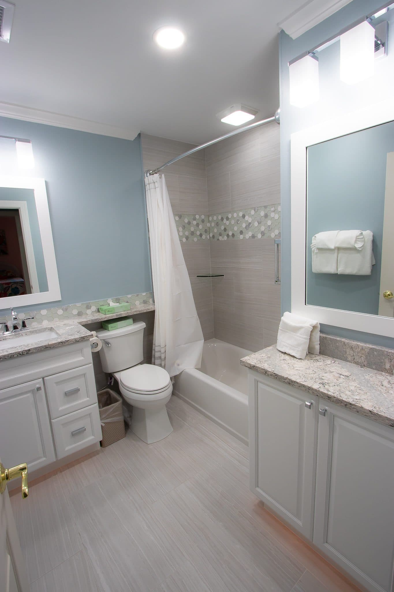 Finished bathroom with blue walls and hexagon tile accent