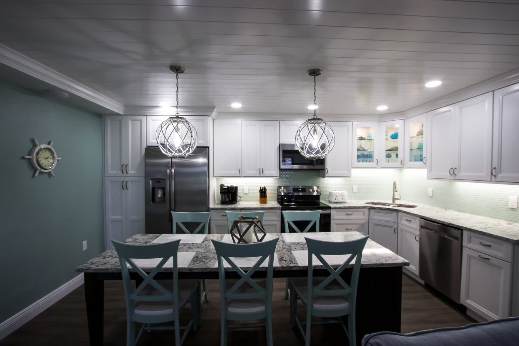 Finished kitchen with teal accents and glass cabinetry