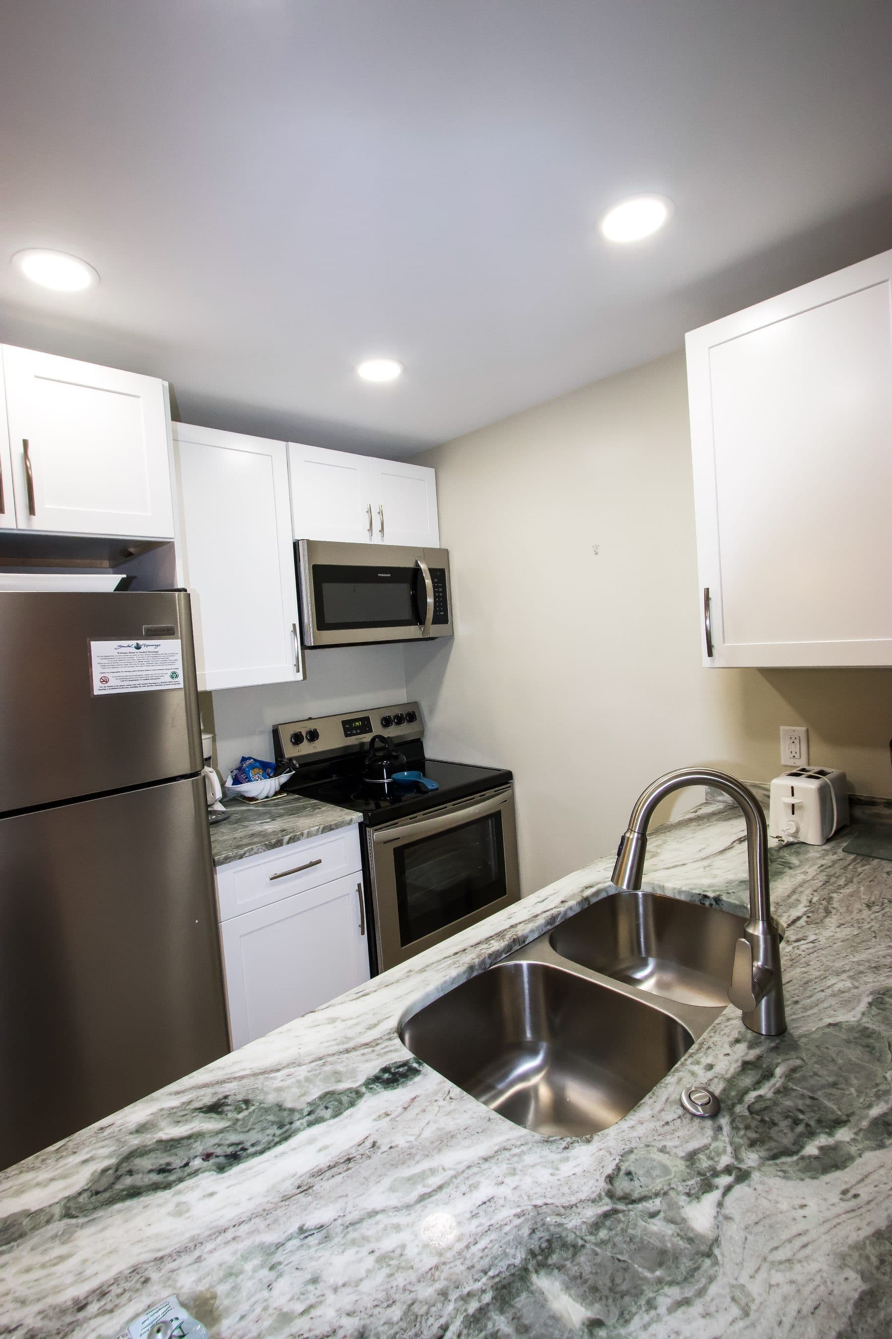 Finished kitchen with stainless appliances and marble counters