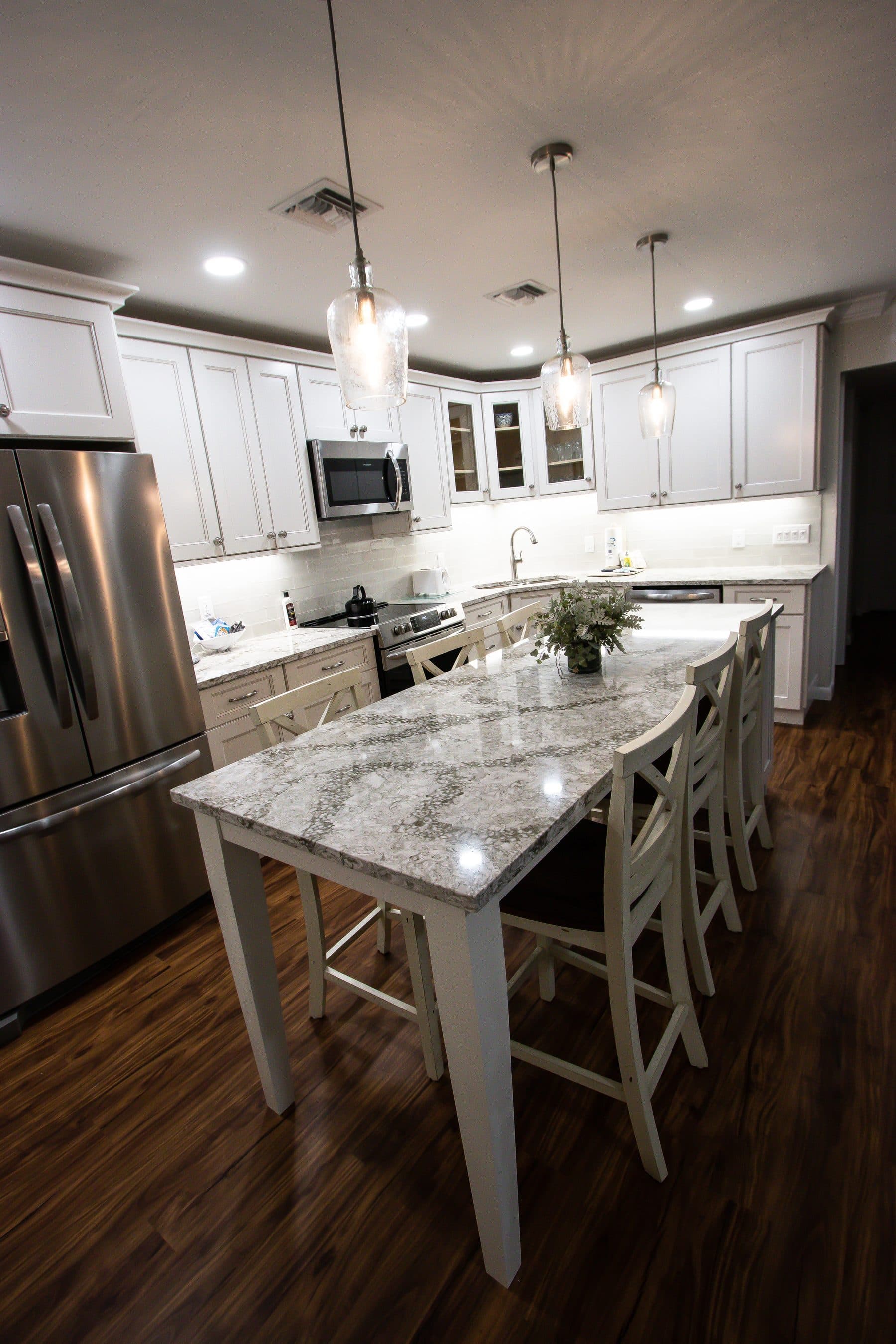 Finished white kitchen with glass pendant lighting