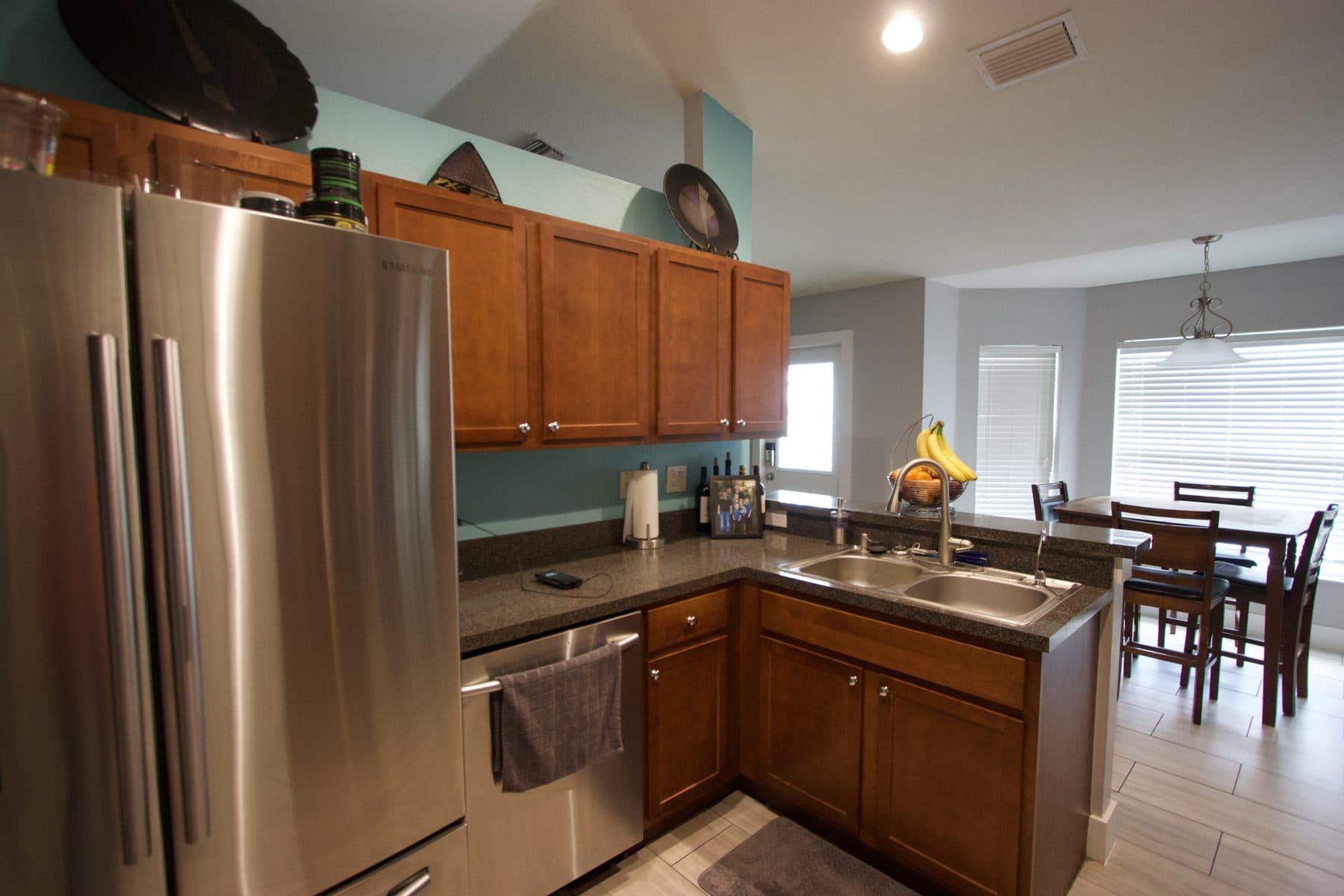Finished kitchen with wood cabinetry and teal accent wall