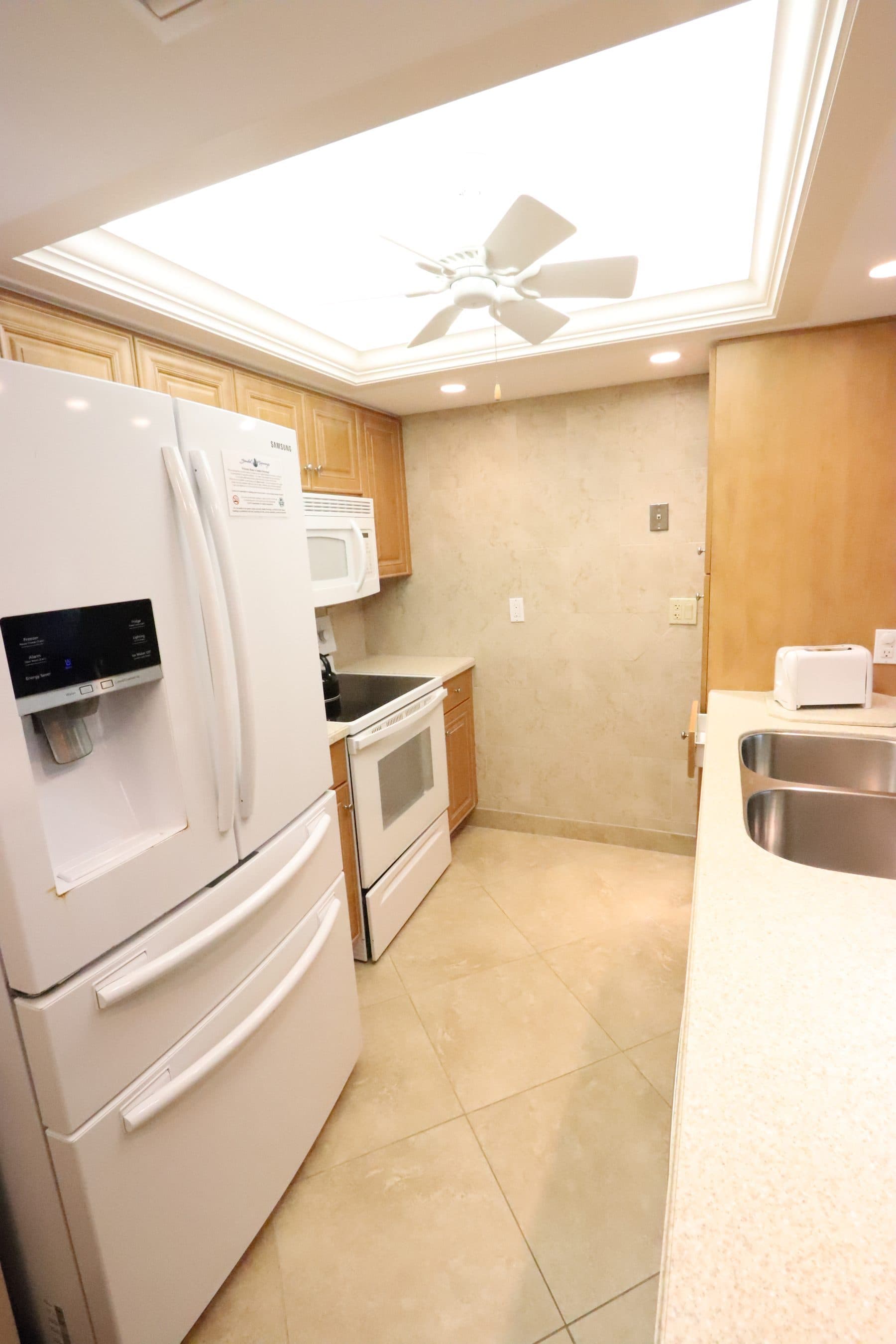 Dated galley kitchen with tan tile