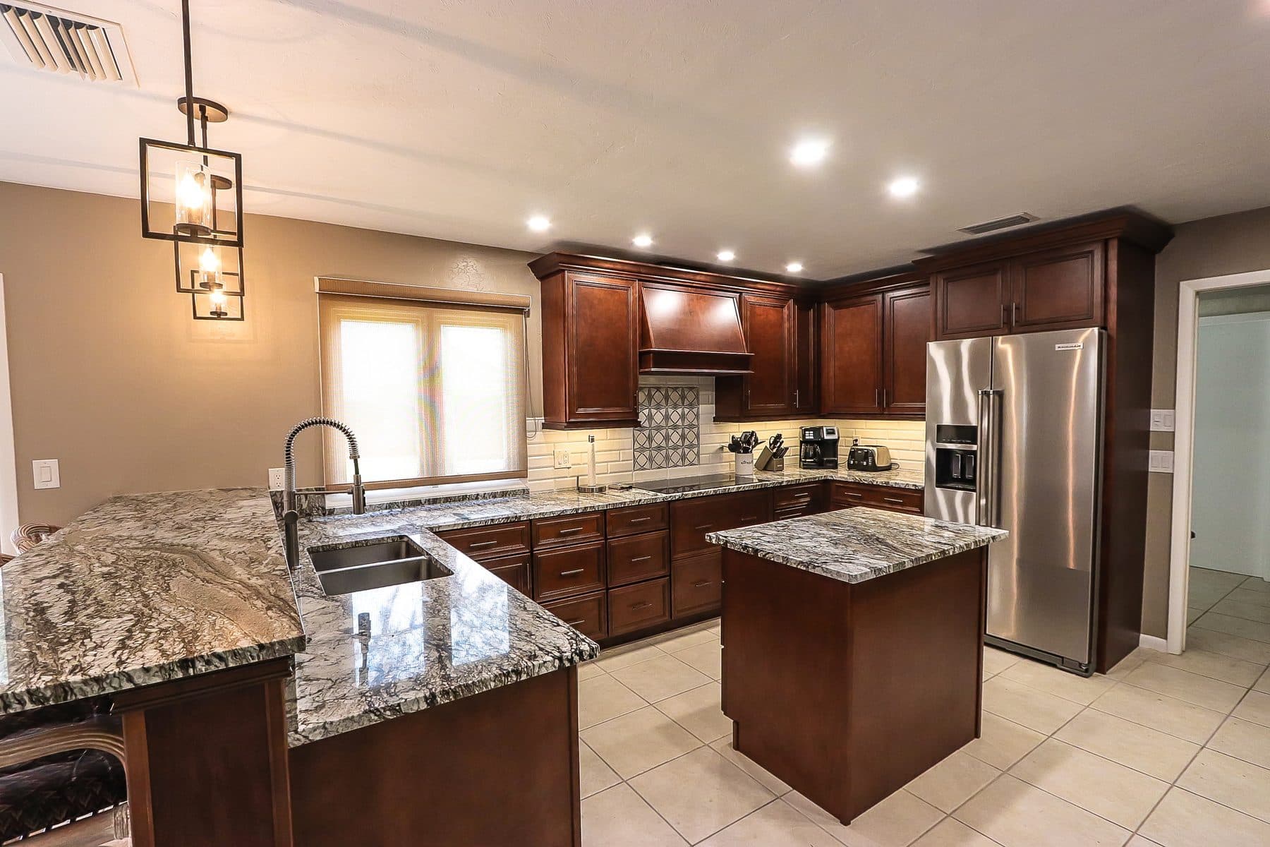Traditional kitchen with dark wood cabinetry and granite