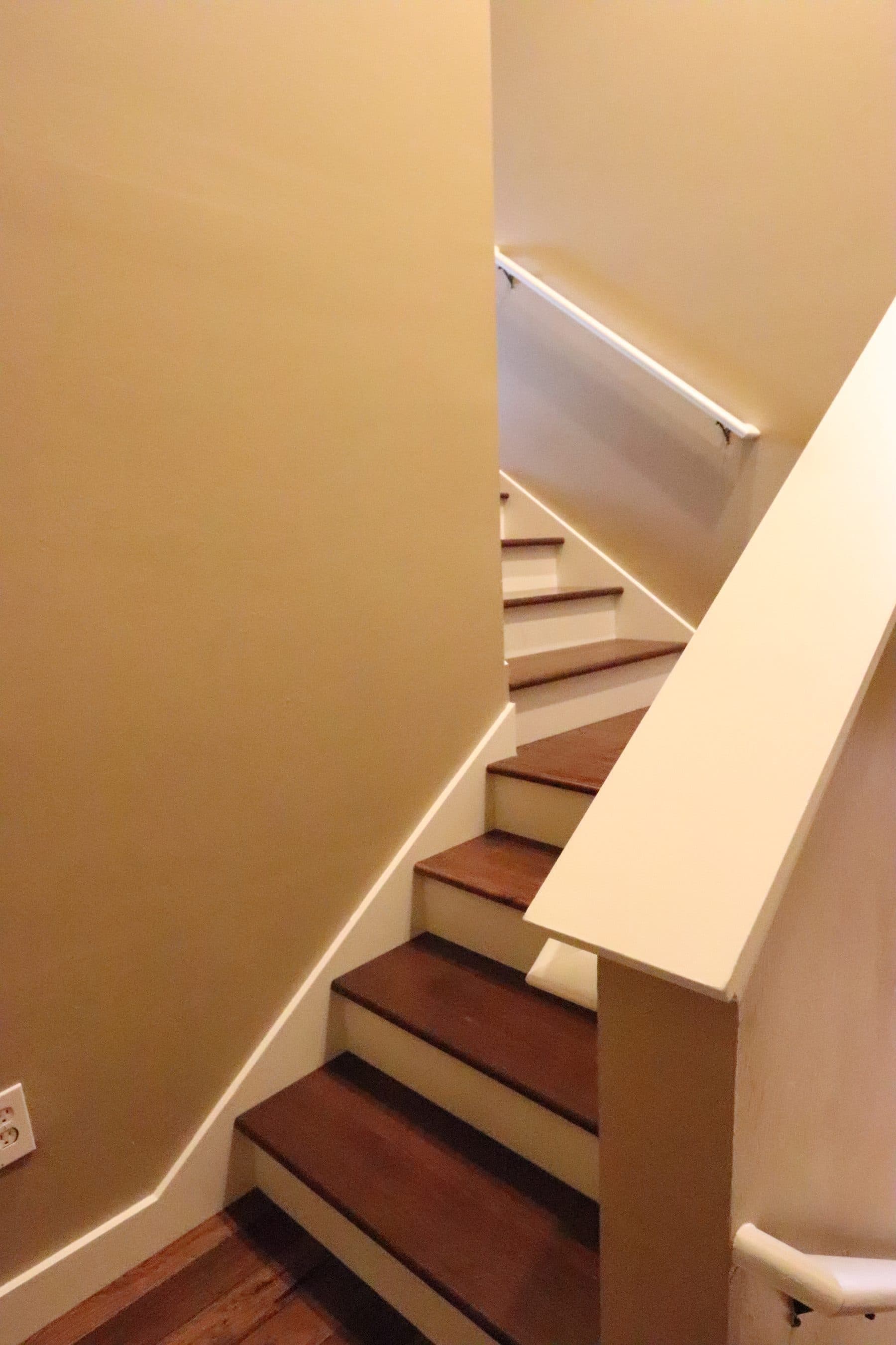 Curved staircase with white risers and wood treads
